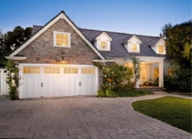  Modern contemporary house with stone features, and white garage doors.