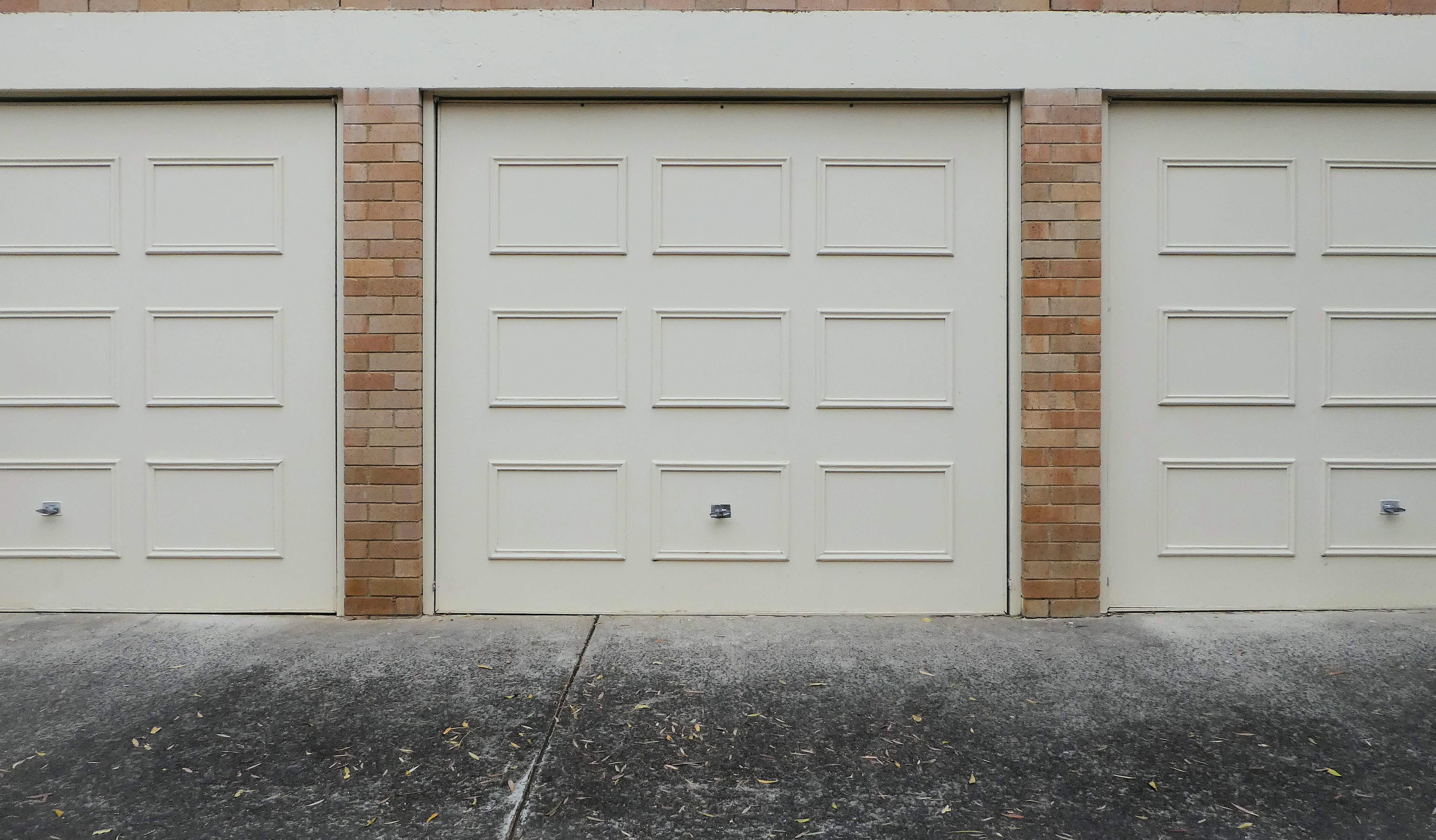 cream residential garage doors with wood panels